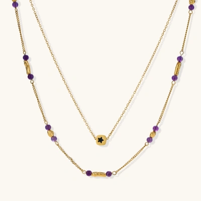 Two layered gold-tone necklaces with purple stone beads and star pendant against cream background.