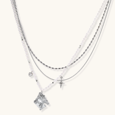 Multi-strand layered necklace set with silver chains, white pearls, star charm, heart pendant, and ornate decorative piece