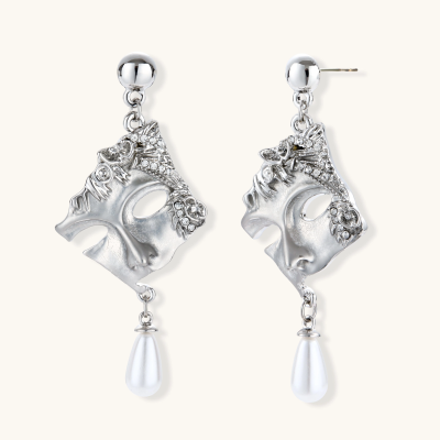 Ornate silver-toned theatrical mask earrings with crystal details and pearl drops on white background.