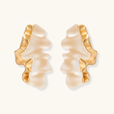 Sculptural wave-textured statement earrings with flowing organic ridges in metallic finish on cream background