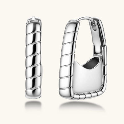 Close-up of platinum-plated sterling silver hoop earrings with horizontal textured grooves on white background.