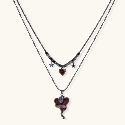 Dark layered necklace set with black chains and red heart pendants, featuring gothic snake design on white background