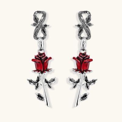 Gothic dangle earrings featuring silver serpent hooks with red enamel roses and metallic stems on white background.