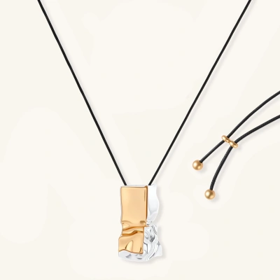 Abstract sculptural pendant necklace with gold and silver toned eco-zinc alloy on black adjustable cord with brass bead details