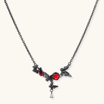 Dark oxidized metal necklace featuring red resin stones set in decorative leaf vine design with crystal drop pendant.
