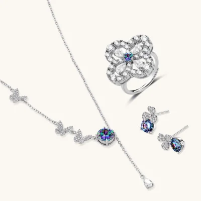 Sterling silver jewelry set with rainbow moissanite stones in clover and butterfly designs on cream background