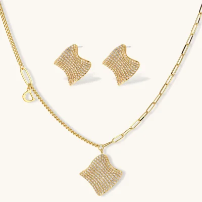Gold-plated wavy jewelry set with crystal detailing featuring necklace with dual chains and matching textured earrings