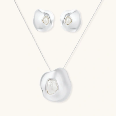 Organic curved earrings and necklace featuring baroque pearls in eco-zinc alloy settings on neutral background