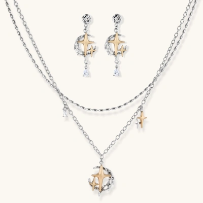Delicate eco-brass jewelry set featuring gold star and silver moon crescents with clear zirconia crystal drops on cream background