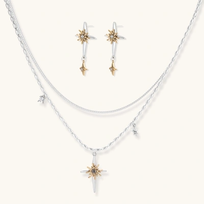 Layered silver-toned necklace set with cross pendant and gold sun charm detail, matching drop earrings on white background.
