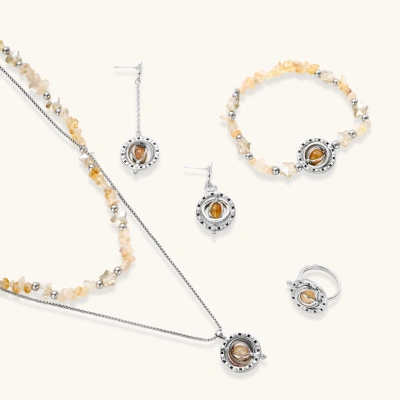 Complete jewelry set featuring citrine stone chips, silver beads, and cosmic circle pendants on cream background.