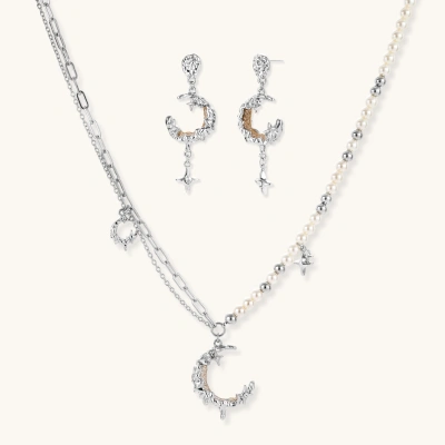 Mixed-metal jewelry set featuring layered necklaces with crescent moon pendant and pearl beads, plus matching star-drop earrings.