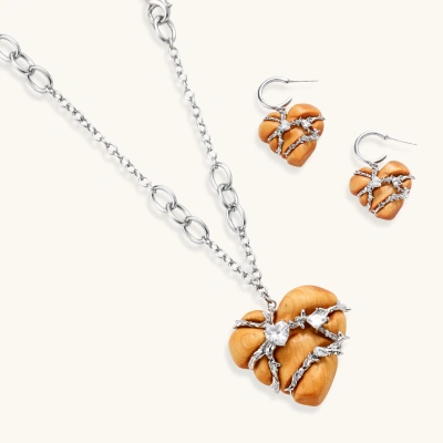 Heart-shaped eco-brass and wood jewelry set with silver wire detailing and crystal accents on cream background.