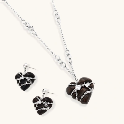 Dark ebony wood heart charms wrapped in intricate silver chains with crystal accents, shown as matching earrings and necklace set.