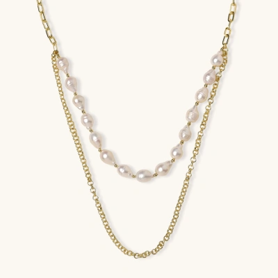 Layered gold chain necklace with organic baroque freshwater pearls and adjustable length on cream background