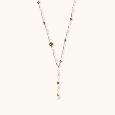 Y-shaped gold-plated necklace with white and gray freshwater pearls on cream background, showing adjustable drop design.
