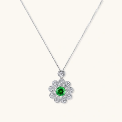 Delicate sterling silver necklace with flower-shaped pendant featuring bright green center moissanite and clear accent stones