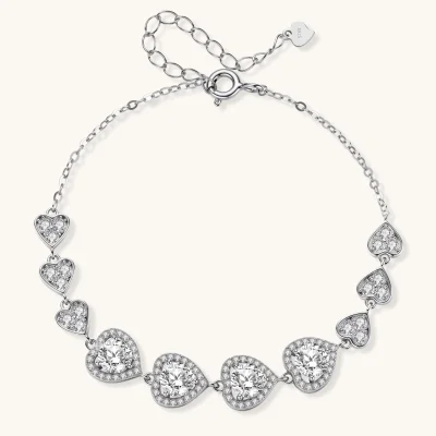 Sterling silver bracelet with graduated heart-shaped links and sparkling moissanite stones in VVS1 clarity on white background.
