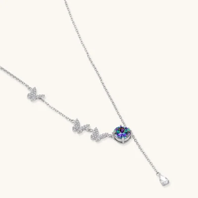 Delicate sterling silver necklace with crystal-set butterfly charms and rainbow moissanite pendant on white background.