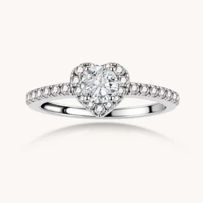 Heart-shaped halo ring with brilliant moissanite center stone surrounded by smaller crystals in sterling silver setting