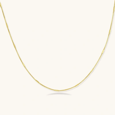 Delicate gold-plated sterling silver chain necklace with geometric segments displayed against cream background
