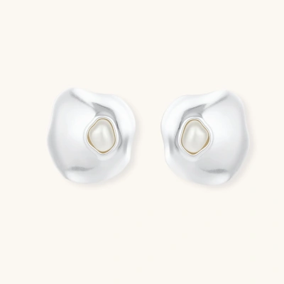 Organic silver stud earrings with white resin pearl centers in fluid stone-like shapes on light background.