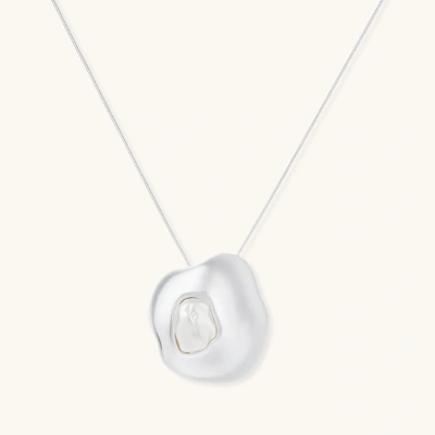 Sculptural silver necklace with flowing organic pendant featuring centered baroque pearl on white background.
