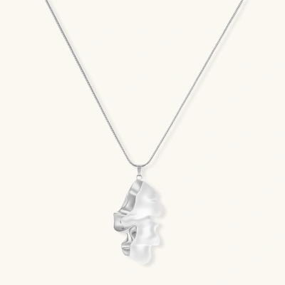 Modern sculptural pendant necklace with twisted metallic design on delicate silver chain against neutral background.