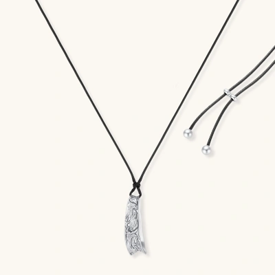 Adjustable black cord necklace with intricate silver-toned pendant featuring ornamental relief patterns and bead details.