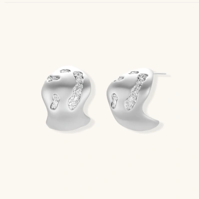 Organic shaped silver stud earrings with sparkling crystal details in flowing molten design on white background.