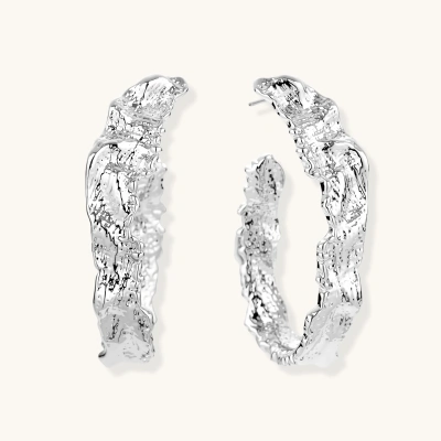 Close-up of textured silver hoop earrings with twisted rope-like pattern and post-back closure on white background.