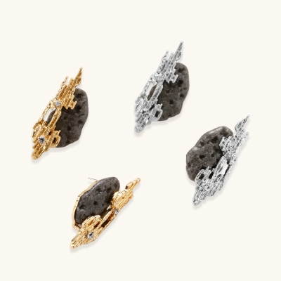 Sculptural gold-toned earrings with textured coral-like design, rhinestone accents, and black volcanic stone elements.