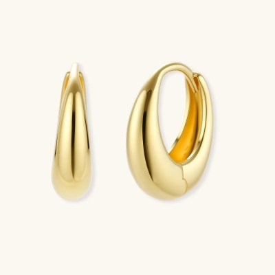 Chunky gold-plated sterling silver huggie hoop earrings with hinged closure mechanism on cream background.