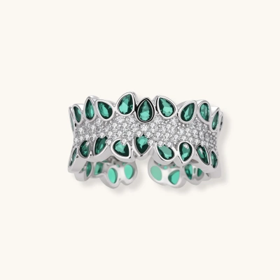 Close-up of adjustable wide band ring with green teardrop zirconia stones in two rows and central clear stones