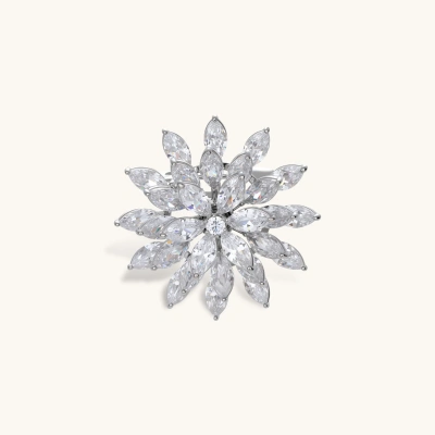 Palladium-plated copper brooch with marquise-cut zirconia stones in radiating flower pattern on cream background.