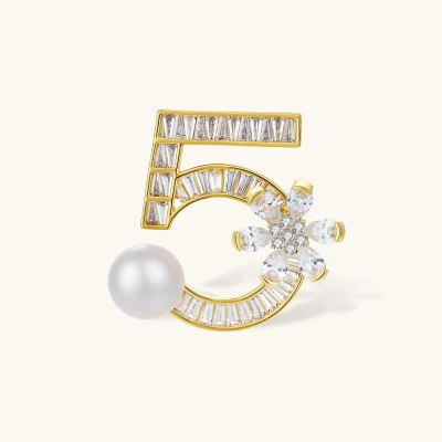 Gold-plated number 5 brooch with white zirconia crystals and floral design featuring a pearl accent on white background.