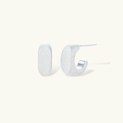Pair of small silver-plated huggie hoop earrings with clean minimal design on neutral background.