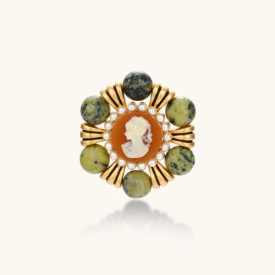 Ornate gold-plated brooch with central cameo, radiating spokes, pearl border, and green marbled natural stones on white background.