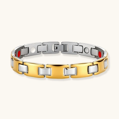 Two-tone gold and silver stainless steel link bracelet with red magnetic inserts and fold-over clasp on cream background.