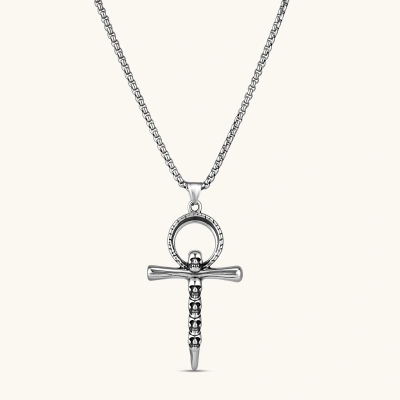 Silver stainless steel ankh pendant with skull motifs on vertical bar and textured ring top, on a box chain necklace.