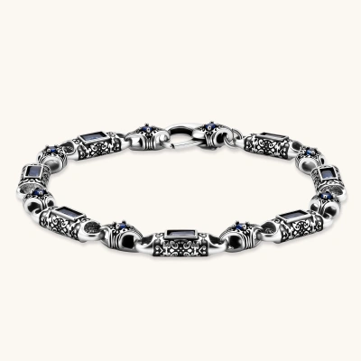 Oxidized silver stainless steel link bracelet with baguette blue CZ stones and intricate scroll engravings, lobster clasp.
