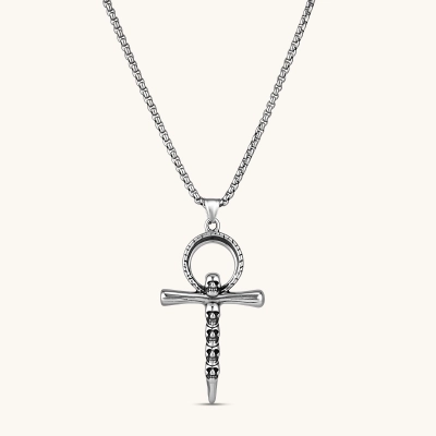 Silver stainless steel ankh pendant with skull motifs on vertical bar and textured ring top, on a box chain necklace.