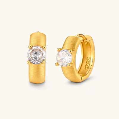 18K gold-plated 925 silver huggie hoops with brushed finish and prong-set round CZ solitaire, stamped S925 inside.