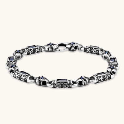Oxidized silver stainless steel link bracelet with baguette blue CZ stones and intricate scroll engravings, lobster clasp.