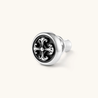 Round sterling silver stud earring with black enamel background and fleur-de-lis cross motif, butterfly push-back closure.