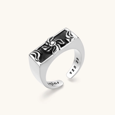 925 sterling silver open signet ring with rectangular black enamel face and raised silver sun-spider motif, adjustable band.