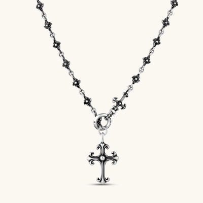Sterling silver necklace with ornate floral-link chain, ring clasp, cross toggle bar, and Gothic fleur cross pendant.