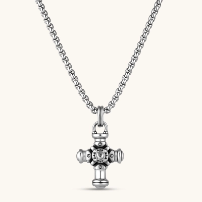 Sterling silver cross pendant with cylindrical arms, floral center medallion, and engraved emblem, shown solo and on a box chain.