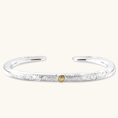 Sterling silver open cuff bracelet with scroll engravings, gold central medallion, and eagle-head terminals. 78mm outer diameter.