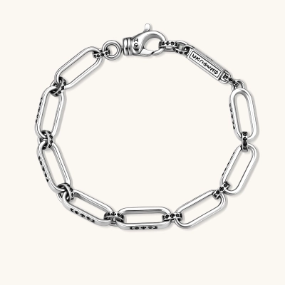 Sterling silver bar-link chain bracelet with oxidized Gothic text engravings and toggle clasp, 7.3mm wide, on white background.
